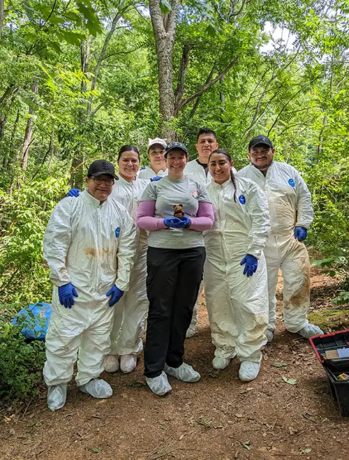 Researchers pose for a photo in the woods